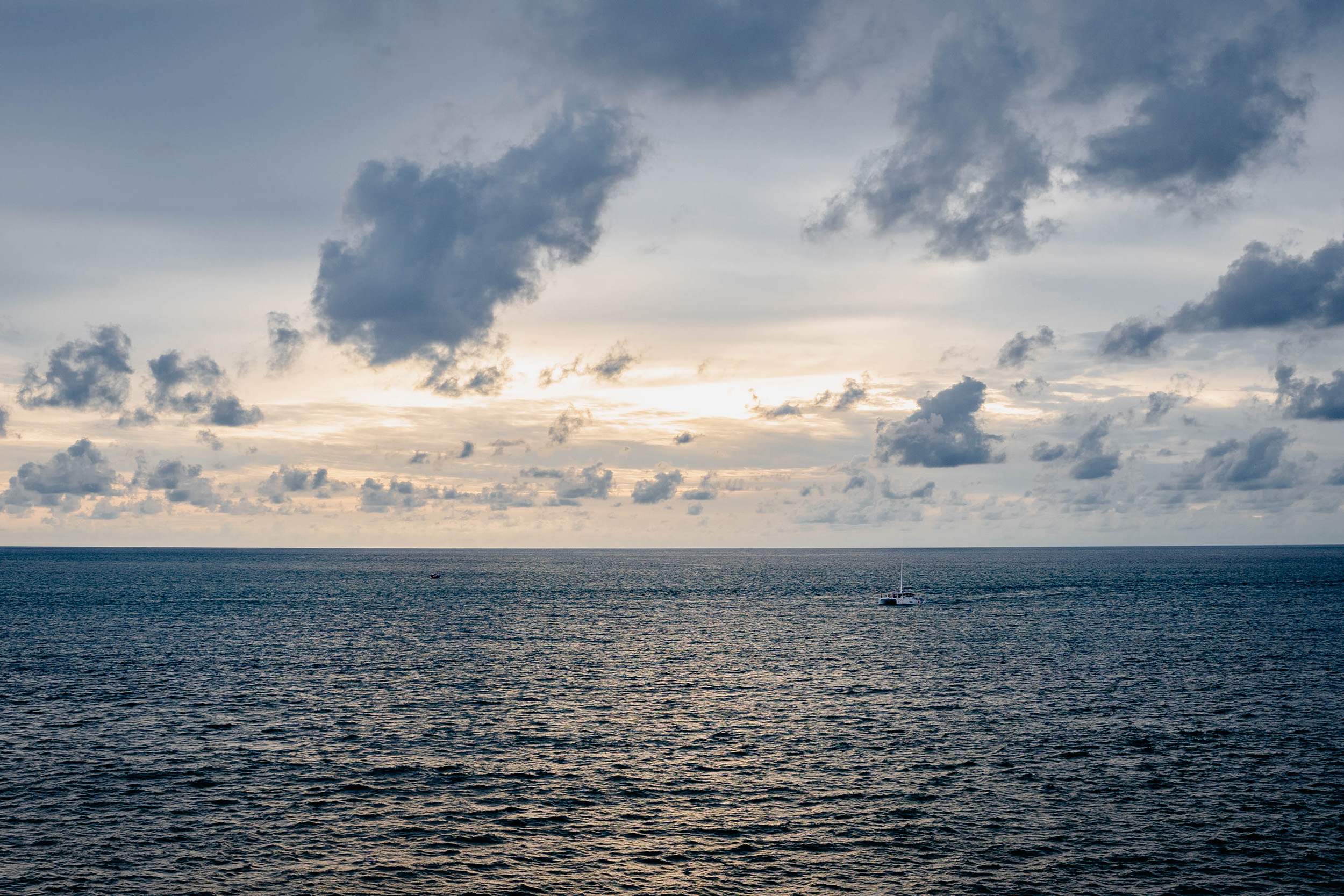 Photo d'un bateau sur la mer avec coucher de soleil